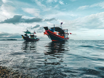 Boat sailing in sea against sky