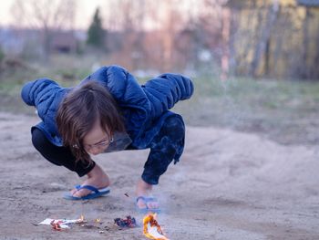 Rear view of boy playing on land