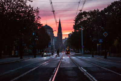 Silhouette person crossing street during sunset