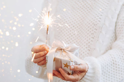 Close-up of woman hand holding illuminated christmas tree