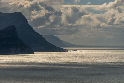 Scenic view of sea and mountains against sky