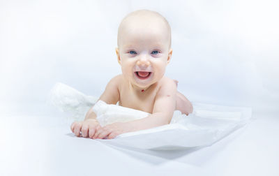 Portrait of cute baby boy lying on bed at home