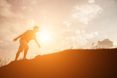 Silhouette man standing against sky during sunset