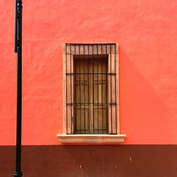 Close-up of window on red wall of building