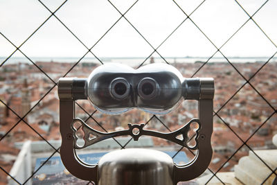 Coin-operated binoculars against cityscape