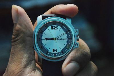 Close-up of hand holding clock