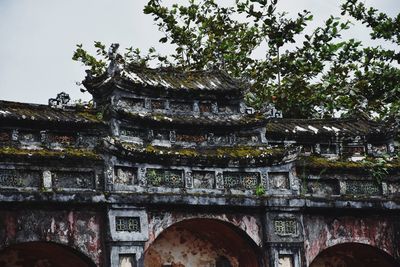 Low angle view of old building and trees against sky