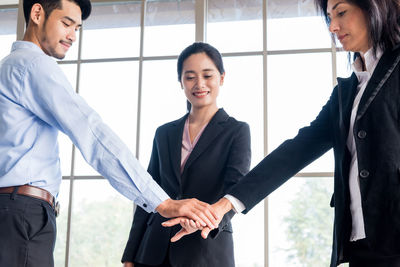 Colleagues stacking hands at office