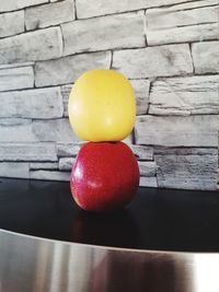 Close-up of fruits on table against wall