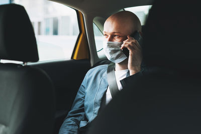 Businessman talking on phone while sitting in taxi