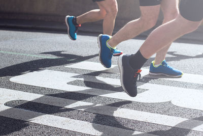 Low section of athletes running on street