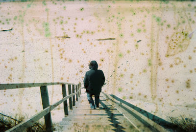 Rear view of man walking on footpath