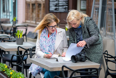 Females looking file at sidewalk cafe