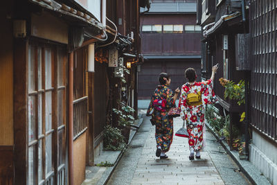 Rear view of people walking outside building