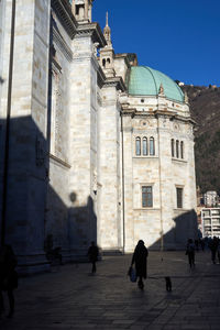 People walking in front of historic building