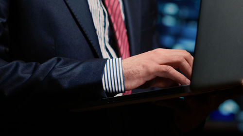 Midsection of businessman using laptop
