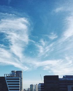 Low angle view of buildings against cloudy sky