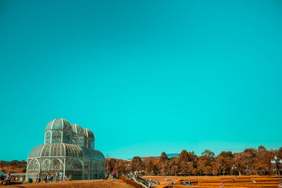 Dome structure on field against clear blue sky