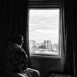 Man looking through window at home