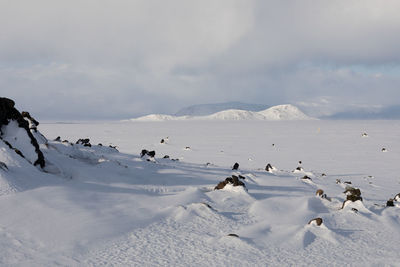 Snow covered land against sky