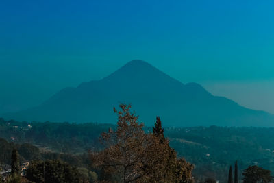 Scenic view of mountains against blue sky