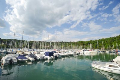 Boats moored in lake against sky