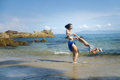 Mother playing with her son on the beach