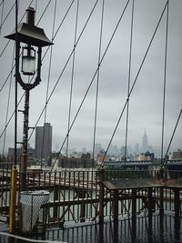 Bridge over river in city against sky