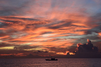 Scenic view of sea against dramatic sky during sunset