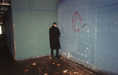 Man urinating in corner of building