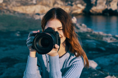 Portrait of young woman photographing camera