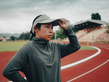 Side view of young woman standing on field