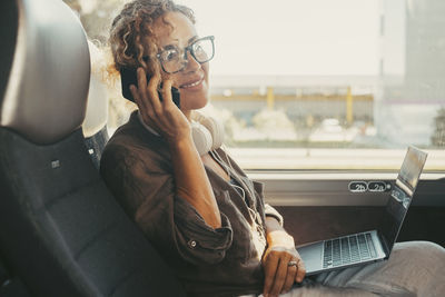 Young woman using mobile phone while sitting in car