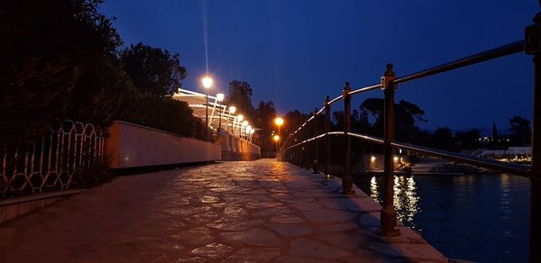 Illuminated bridge over canal in city at night