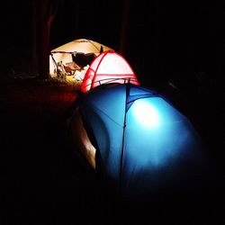 Rear view of illuminated tent against black background