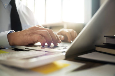 Midsection of man using laptop on table