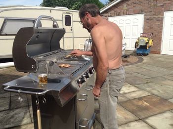 Midsection of shirtless man standing in kitchen