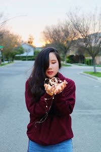 Beautiful young woman on road at park during sunset