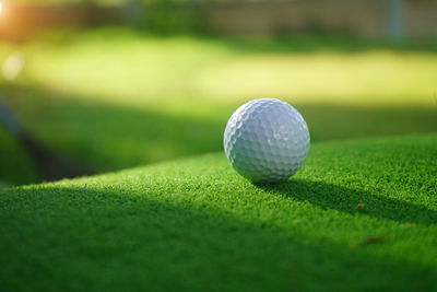 Golf ball on the green with warm tone and sunset. 