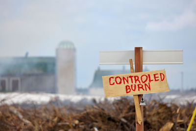 Controlled burn sign  with active burn in background on a farm property to create more arable land