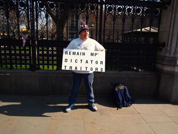 Portrait of man standing on footpath