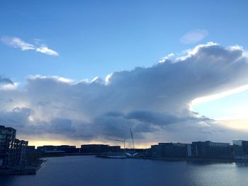 River in city against cloudy sky
