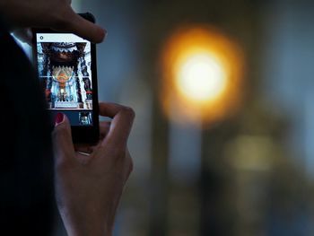 Cropped hands of woman photographing in cathedral