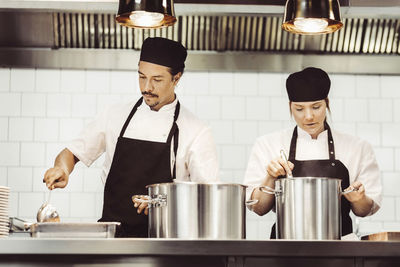 Chefs preparing food at kitchen counter