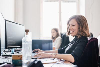 Portrait of businesswoman using laptop at office