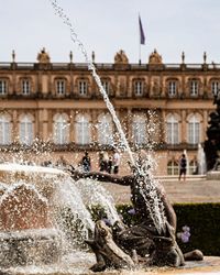 Water fountain against buildings in city