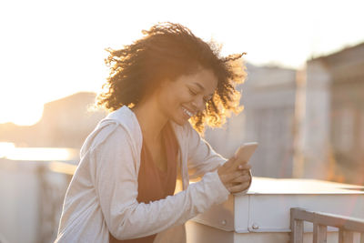 Young woman using mobile phone against white background