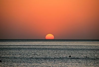 Scenic view of sea against orange sky