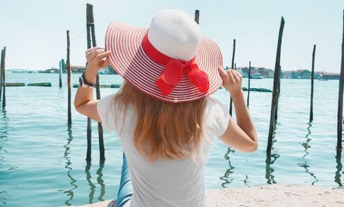 Rear view of woman standing against sea