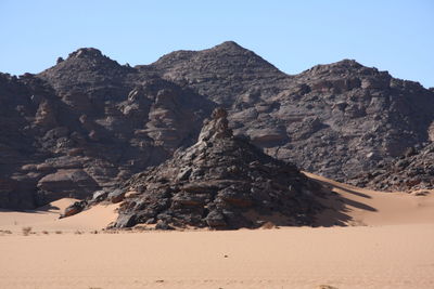 Scenic view of rocky mountains against clear sky akakus mountain, libya